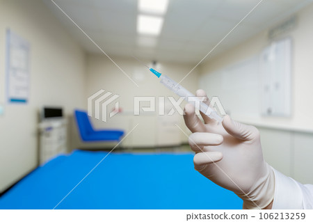The doctor shows a syringe with medicine. The doctor shows a syringe with medicine. 106213259