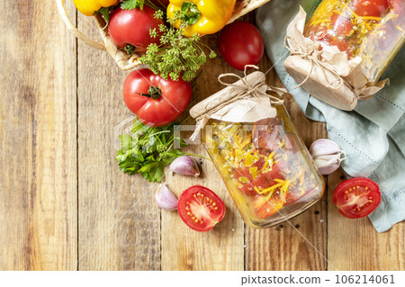 Healthy homemade fermented food. Salad tomatoes with vegetables on a rustic table. Home economics, autumn harvest preservation. View from above. Copy space. 106214061