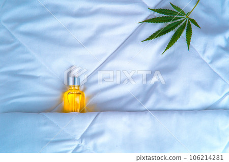 Bottle of cannabis oil, CBD, marijuana leaf, sleeping under covers Bottle of cannabis oil, CBD, marijuana leaf, sleeping under covers 106214281