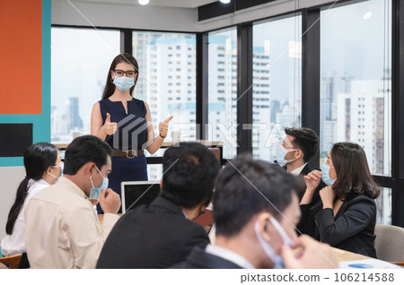 Caucasian executive woman showing thumbs up with proposes company policy on wearing face mask in company during meeting 106214588