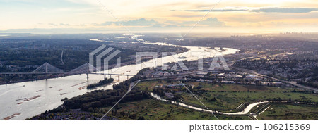 Aerial View of Fraser River and City. Cloudy Sunset Sky. Panorama. Pitt Meadows, Vancouver, BC, Canada Aerial View of Fraser River and City. Cloudy Sunset Sky. Panorama. Pitt Meadows, Vancouver, BC, Canada 106215369