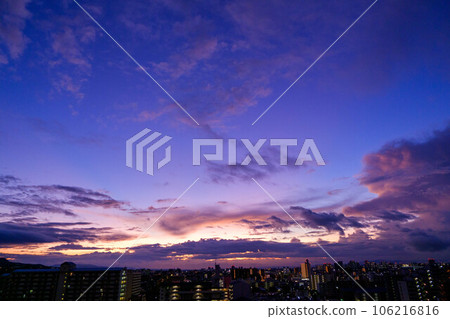 Dawn in the city. The eastern sky brightens and the sun before the clouds rise shows a beautiful gradation. Kobe city Dawn in the city. The eastern sky brightens and the sun before the clouds rise shows a beautiful gradation. Kobe city 106216816
