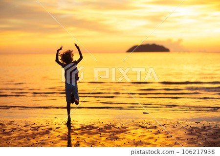 Child playing on ocean beach. Kid at sunset sea. 106217938