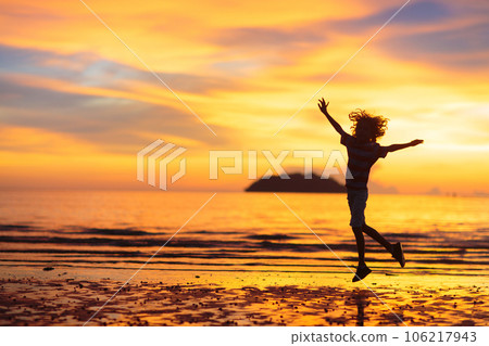 Child playing on ocean beach. Kid at sunset sea. 106217943