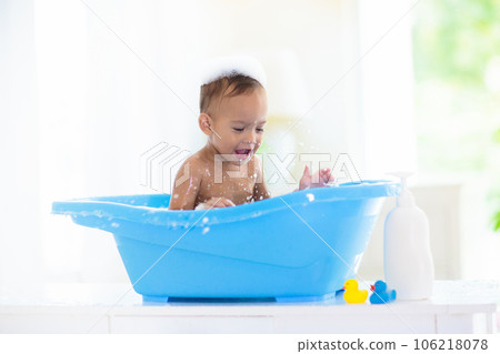 Baby boy in bath. Mother washing infant child. 106218078