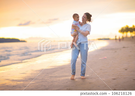 Mother and baby on tropical beach at sunset. 106218126