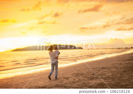 Mother and baby on tropical beach at sunset. 106218128