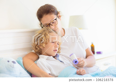 Sick child in bed. Mother checking on unwell kid. Sick child in bed. Mother checking on unwell kid. 106218378
