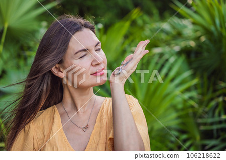 pregnant woman after 40 demonstrating the use of an aroma pendant, combining style and aromatherapy during her pregnancy journey 106218622