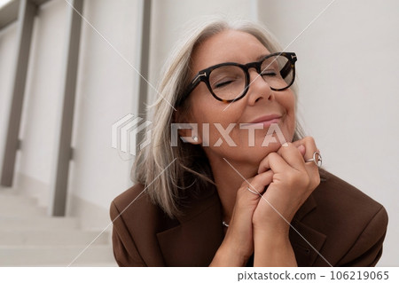60 year old well-groomed slender gray-haired business woman dressed stylishly enjoys freedom during 106219065