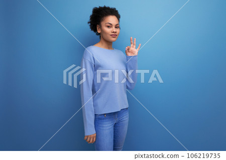 authentic latin brunette woman with curly hair rejoices against the background with copy space 106219735