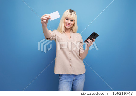 portrait of wealthy european blonde young lady with shopping card and smartphone on background with portrait of wealthy european blonde young lady with shopping card and smartphone on background with 106219748