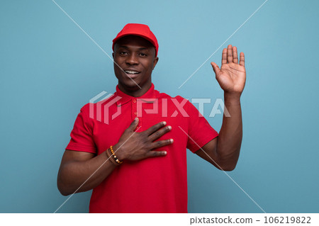 corporate color. american man wearing red t-shirt and cap on background with copy space corporate color. american man wearing red t-shirt and cap on background with copy space 106219822