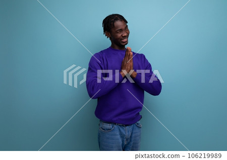 funny dark-skinned american young brunette man with dreadlocks in a blue sweatshirt 106219989