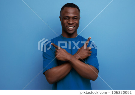 inspired young smart american man in t-shirt gesturing with hands on blue background with copy space 106220091