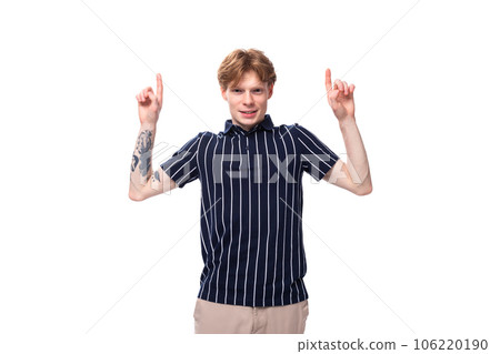 caucasian cute 25s blond man with tattoos points his finger 106220190