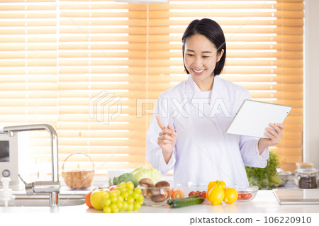 nutritionist looking at tablet nutritionist looking at tablet 106220910