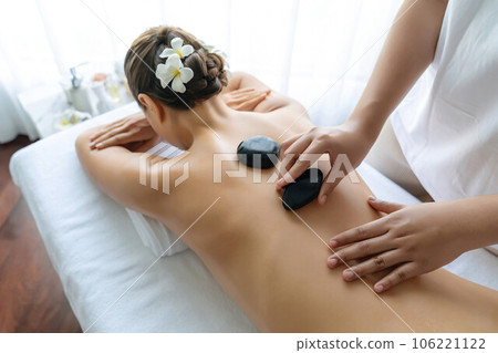 Hot stone massage at spa salon in luxury resort. Quiescent 106221122