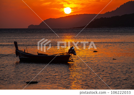amazing yellow sky of sunrise above the island. The brilliant yellow hue of the sky created a breathtaking scene as the sun slowly rose over the island. fishing boats parking on the golden sea. amazing yellow sky of sunrise above the island. The brilliant yellow hue of the sky created a breathtaking scene as the sun slowly rose over the island. fishing boats parking on the golden sea. 106222033