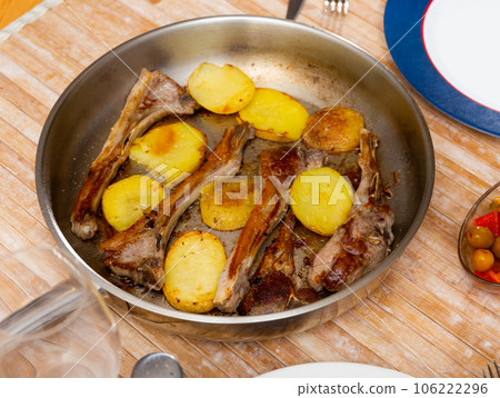 Seared and roasted lamb ribs served with baked potato on table, top view. Seared and roasted lamb ribs served with baked potato on table, top view. 106222296