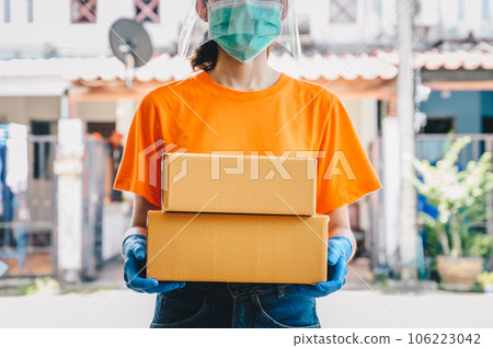 Delivery service courier holding boxes mail for sending to customer while wearing mask and glove for protect herself in covid-19 pandemic outbreak. Delivery service courier holding boxes mail for sending to customer while wearing mask and glove for protect herself in covid-19 pandemic outbreak. 106223042