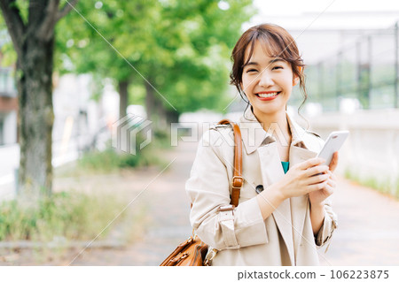 A young woman with a smartphone outdoors A young woman with a smartphone outdoors 106223875