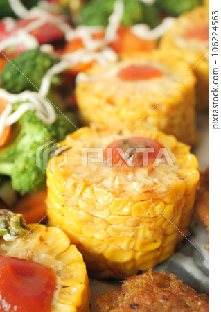 Ears of corn baked with herbs on white baking paper Ears of corn baked with herbs on white baking paper 106224563