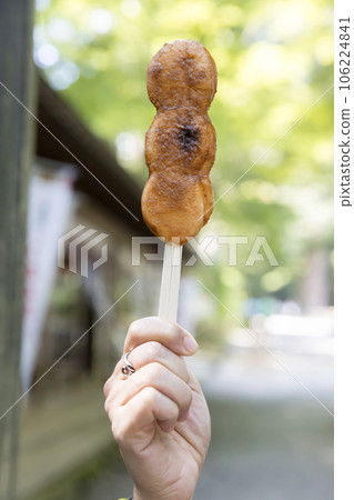 A woman's hand holding the famous Benkei mochi in the precincts of Chusonji Temple 106224841