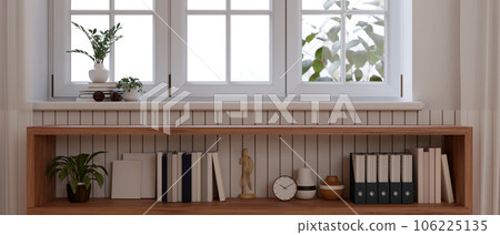 Copy space on a wooden open shelf cabinet in a minimalist white living room. Copy space on a wooden open shelf cabinet in a minimalist white living room. 106225135