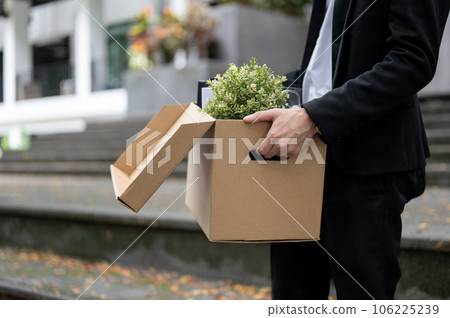 Cropped image of a businessman is carrying a box of his personal stuff, losing his job. 106225239