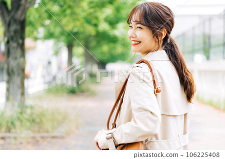 A woman wearing a trench coat and bra in the city 106225408