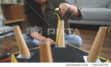 Women use measure tape equipment to measurement length of chair leg while making handmade furniture Women use measure tape equipment to measurement length of chair leg while making handmade furniture 106226794