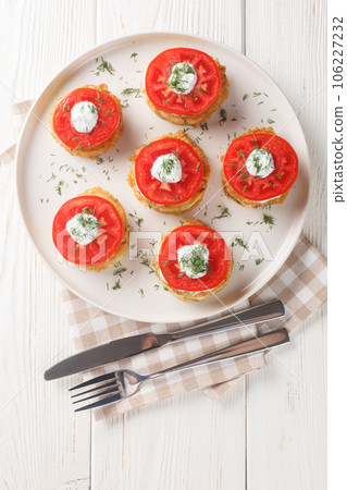 Pan fried zucchini in egg batter served with fresh tomato and creamy sauce close-up in a plate. Vertical top view Pan fried zucchini in egg batter served with fresh tomato and creamy sauce close-up in a plate. Vertical top view 106227232