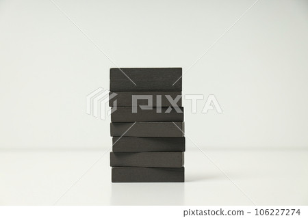 Tower of black wooden blocks on white background. World autism day concept Tower of black wooden blocks on white background. World autism day concept 106227274