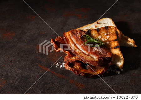 Tasty breakfast and delicious meat food concept - fried bacon 106227370