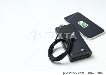 Powerbank, smartphone and cord on white background, space for text 106227882