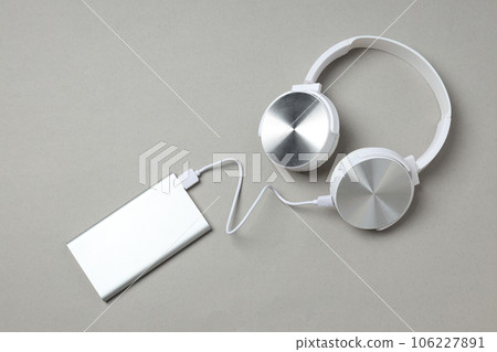 Powerbank and headphones on gray background, top view 106227891