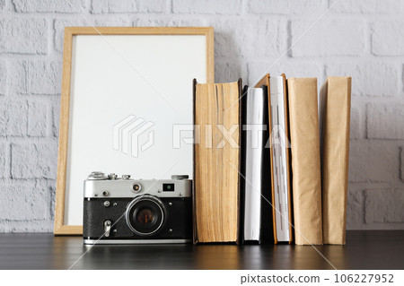Vintage camera, photo frame and books on table on white background 106227952