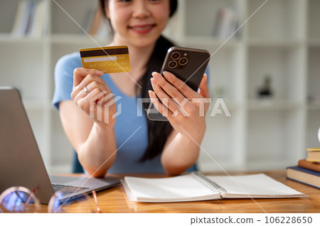 Close-up image of a woman enjoys shopping online at home and pay with her credit card. 106228650