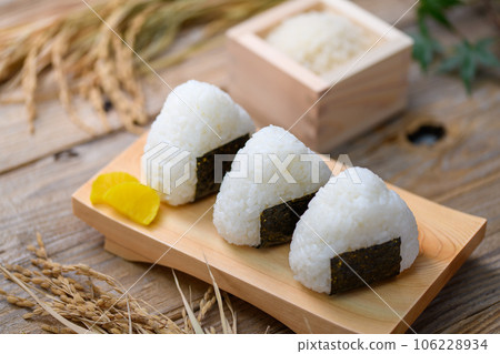 Hand-made rice balls Rice balls wrapped in nori seaweed and served with rice (onigiri) and pickled radish 106228934