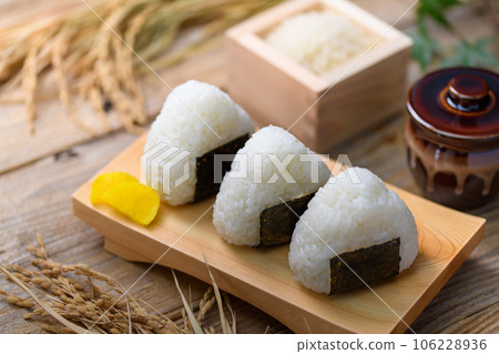 Hand-made rice balls Rice balls wrapped in nori seaweed and served with rice (onigiri) and pickled radish 106228936