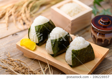 Hand-made rice balls Rice balls wrapped in nori seaweed and served with rice (onigiri) and pickled radish 106228937