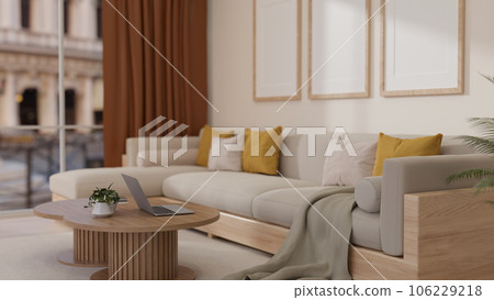 A laptop is on a minimal wooden coffee table in a modern and cozy apartment living room. 106229218