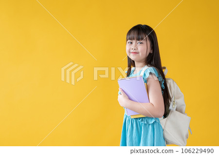An adorable young Asian girl with books in her hand and a backpack. kids, elementary school student An adorable young Asian girl with books in her hand and a backpack. kids, elementary school student 106229490
