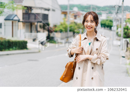 A woman wearing a trench coat and bra in the city 106232041
