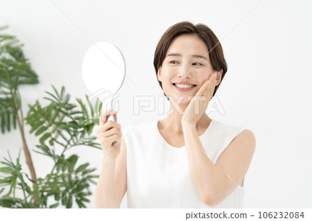 一個女人看著鏡子微笑著美麗 106232084
