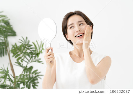 一個女人看著鏡子微笑著美麗 106232087