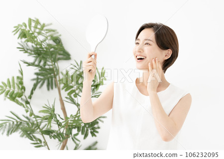 A woman looking in the mirror and smiling Beauty 106232095