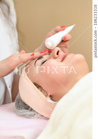 Applying cream on the face in a spa salon. Applying cream on the face in a spa salon. 106233316