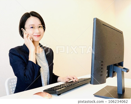 A woman making a phone call while working remotely A woman making a phone call while working remotely 106234062